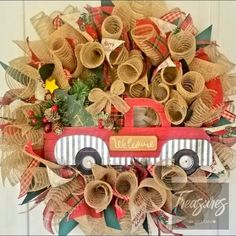 a red truck wreath with burlocks and pine cones