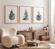 three paintings hang on the wall above a chair and table in a room with wood flooring