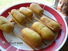 some food is sitting on a red and white plate with toothpicks in it