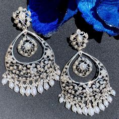 Indulge in the allure of heritage and sophistication with our sterling silver chandbali earrings, featuring delicate floral motifs and exquisite pearls. Crafted to perfection, these earrings seamlessly blend tradition with modern elegance, adding a touch of opulence to any ensemble. Elevate your style with timeless grace and charm, as each pair whispers tales of luxury and refinement. Fusion Style Chandelier Earrings With Pearl Drop For Celebration, Fusion Style Pearl Drop Chandelier Earrings For Celebration, Fusion Style Pearl Drop Danglers For Celebrations, Traditional Silver Earrings With Elegant Design, Pearl Drop Chandbalis For Celebration, Festive Fusion Style Pearl Drop Danglers, Sterling Silver Teardrop Bridal Earrings With Elegant Design, Luxury Silver Bridal Earrings With Elegant Design, Elegant Teardrop Sterling Silver Bridal Earrings