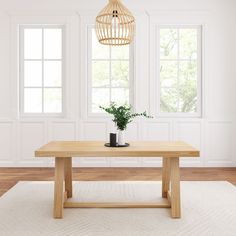 a wooden table sitting on top of a white rug next to two windows and a potted plant