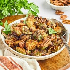 a white bowl filled with brussel sprouts and pecans