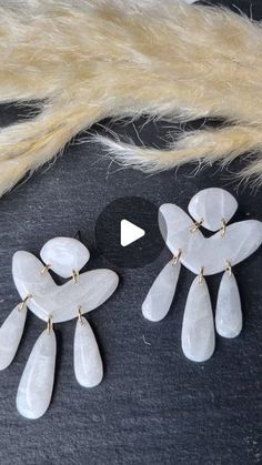 two pairs of white earrings on top of a fur