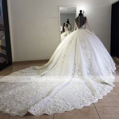 the back of a wedding dress is shown in front of a mirror and mannequins