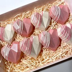 several pink and white heart shaped candys in a box