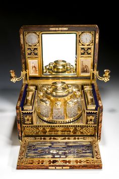 an old fashioned machine with gold decorations on it's sides and two mirrors in the back