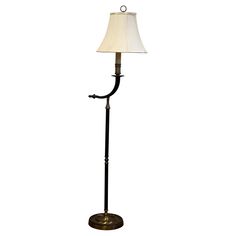 a floor lamp with a white shade on it's base and a black metal pole