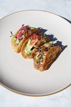 two pieces of bread on a white plate with red and green salad in the middle