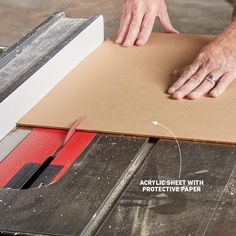 a man is working on a piece of cardboard