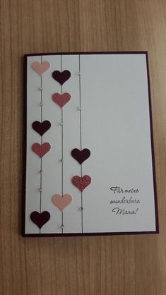 a card with hearts hanging from strings