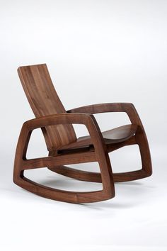 a wooden rocking chair sitting on top of a white floor