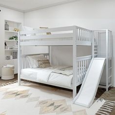 a bunk bed with a slide next to it in a room that has white walls