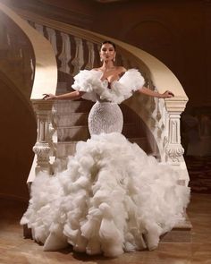 a woman in a white dress standing on stairs