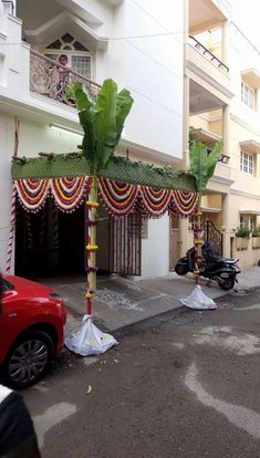 a car parked in front of a building decorated with flowers and garlands on the street