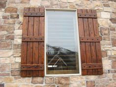 a window with wooden shutters on a stone wall