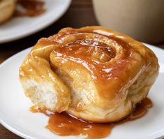 a close up of a pastry on a plate with syrup drizzled around it