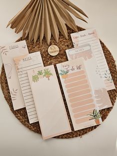 the stationery is laid out on top of the wicker basket with palm fronds