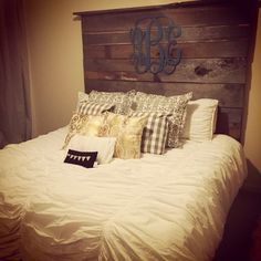 a bed with white sheets and pillows on top of it next to a wooden headboard