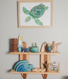 two wooden shelves holding various items in front of a framed turtle painting on the wall