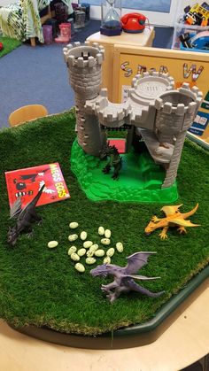 some toys are sitting on the grass in front of a castle and other items for play