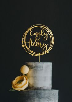 a wedding cake with an embellished topper on it and a yellow flower