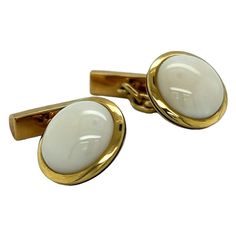 These cufflinks are a stunning piece of jewelry that exudes elegance and sophistication. The cufflinks are crafted from 18k yellow gold, a high-quality material that is known for its durability, luster, and rich color. The gold is carefully crafted to create a sleek and polished design that is both eye-catching and refined. At the center of each cufflink, you will find a striking piece of white coral. White coral is a unique and rare gemstone that is prized for its exquisite beauty and purity. T Luxury Yellow Gold Classic Cufflinks, Gold Cufflinks, White Coral, Rare Gemstones, Black Enamel, Classic Elegance, Rich Color, The White, Contemporary Style