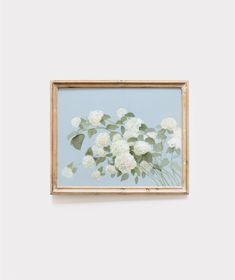 a painting hanging on the wall with white flowers