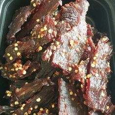 a plastic container filled with beef strips covered in seasoning