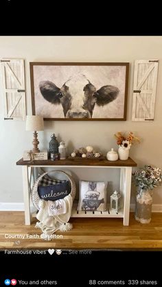 a shelf with pictures and other items on it in front of a cow's head