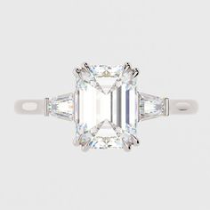 an emerald cut diamond ring with three baguets