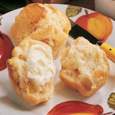 three biscuits on a white plate with orange and yellow leaves around them next to a knife