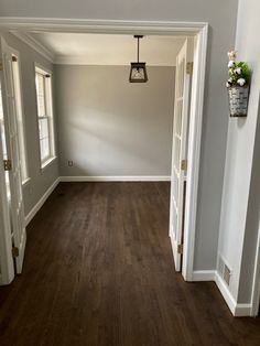 an empty living room with hard wood floors and white trim on the walls is shown