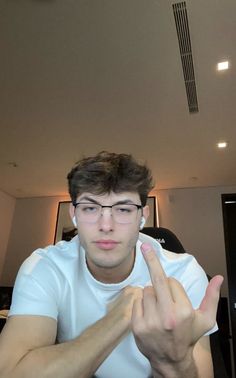 a man sitting at a table making the peace sign