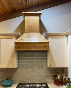 a stove top oven sitting inside of a kitchen next to white cabinets and counter tops