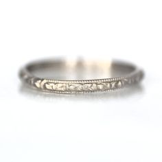 a close up view of an antique wedding ring on a white background with the word love written in it