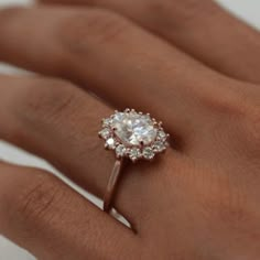 a woman's hand with a diamond ring on top of her finger and an engagement band