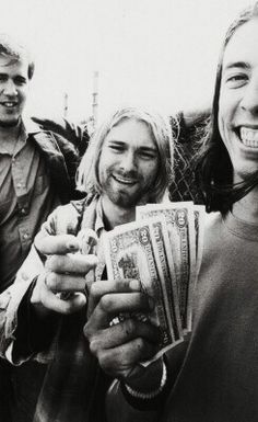 three people are smiling and holding cash in their hands