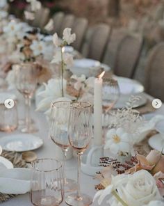 the table is set with wine glasses, plates and napkins for an elegant dinner