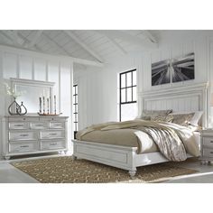 a white bed sitting in a bedroom next to a dresser and mirror on top of a wooden floor