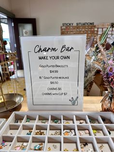 a sign that says charm bar make your own on display in a jewelry store window