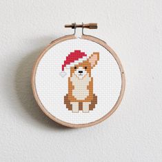 a cross stitch pattern with a dog wearing a santa hat