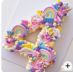 the letter e is made out of fondant and decorated with rainbows, unicorns, clouds, and flowers