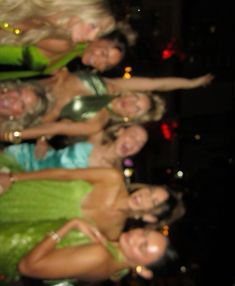 four women in green dresses posing for the camera