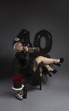 a woman sitting on top of a chair next to a cake