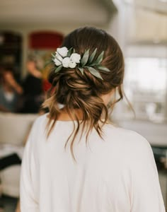 the back of a woman's head with flowers in her hair