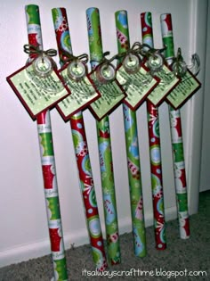 four christmas themed toothbrushes with tags attached to them, all decorated in green and red