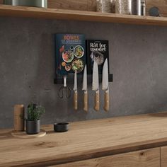 two knives are hanging on the wall next to some cookbooks and utensils