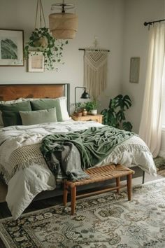 a bedroom with a large bed covered in green blankets and pillows, along with hanging plants on the wall