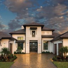 a large white house with brown shutters on the front and side doors, windows, and landscaping