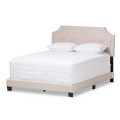 a white bed with two pillows on top of the headboard and night stands underneath it